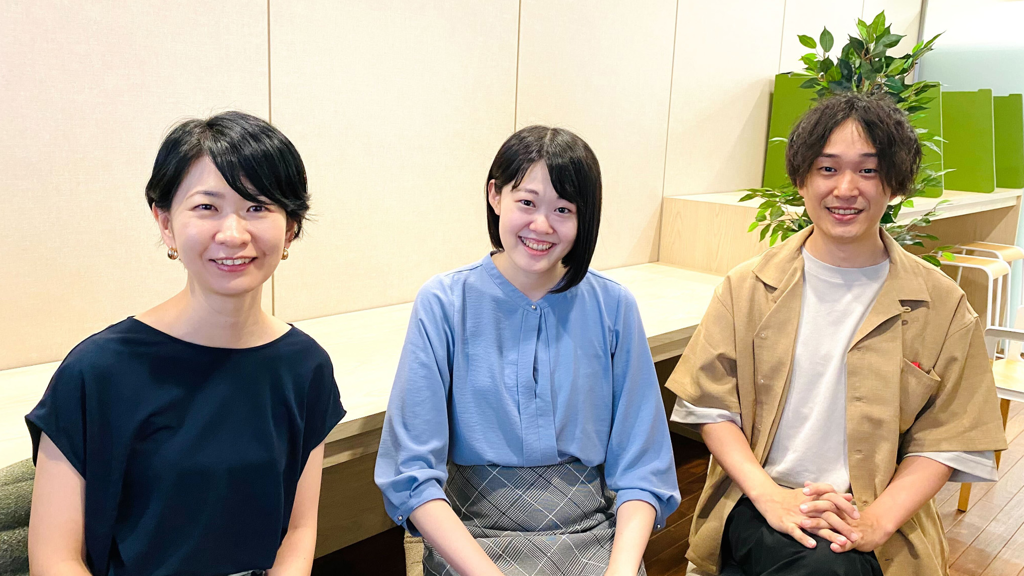 ドコモ社員3人が椅子に座って微笑んでいる様子