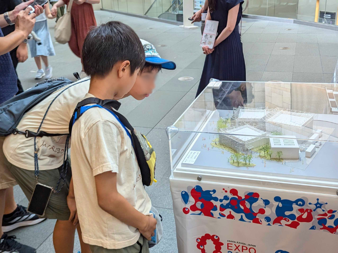 子どもたちがパビリオン模型を眺めている様子