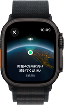 Apple Watch Ultra 3、ブラックチタニウムケース、地球の地図上にユーザーの位置が表示され、「衛星の方向に向け続けてください」という文字が重なっている。アルパインループバンド