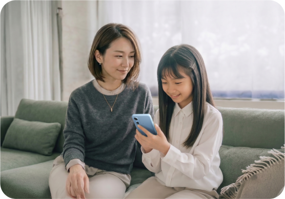 お子さまと一緒にスマートフォンを見る親子