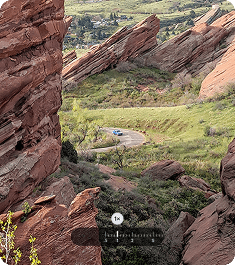 最大100倍の超解像ズームProで、1.0倍で遠くから青い車を撮影する様子