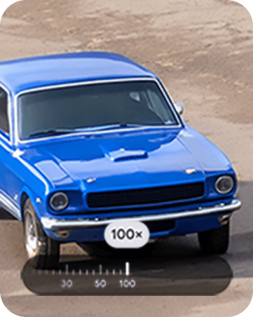 最大100倍の超解像ズームProで、100倍で遠くから青い車を撮影する様子