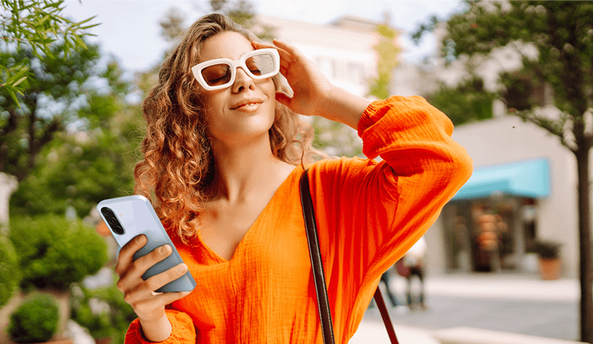 日差しの強い屋外でSamsung Galaxy A36 5Gを使用する女性