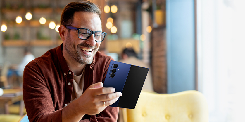 Samsung Galaxy Z Fold7を笑顔で使用する男性の画像