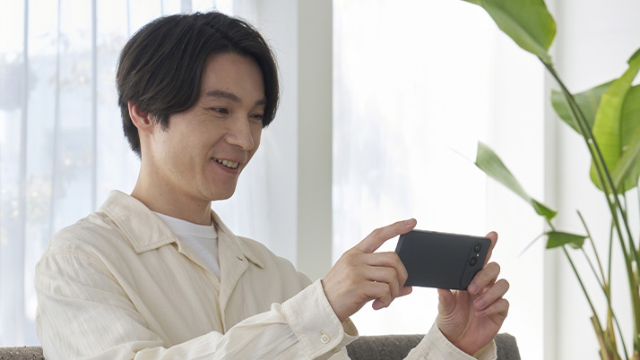 男性がスマートフォンのディスプレイを見ている様子