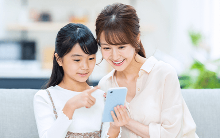 一緒にスマートフォンを見ている親子