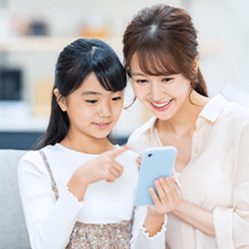 一緒にスマートフォンを見ている親子