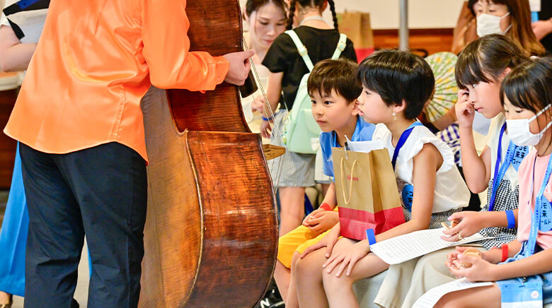 NHK交響楽団 | 2024 ドコモ未来フィールド | NHK交響楽団が演奏する様子とそれに目を奪われる子どもたちの様子