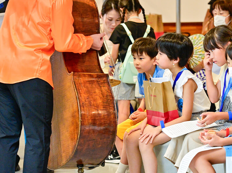 NHK交響楽団 | 2024 ドコモ未来フィールド | NHK交響楽団が演奏する様子とそれに目を奪われる子どもたちの様子