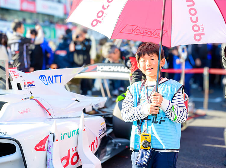 ダンディライアンレーシング | 2025 ドコモ未来フィールド | フラッグやパラソルを掲げている子どもたち